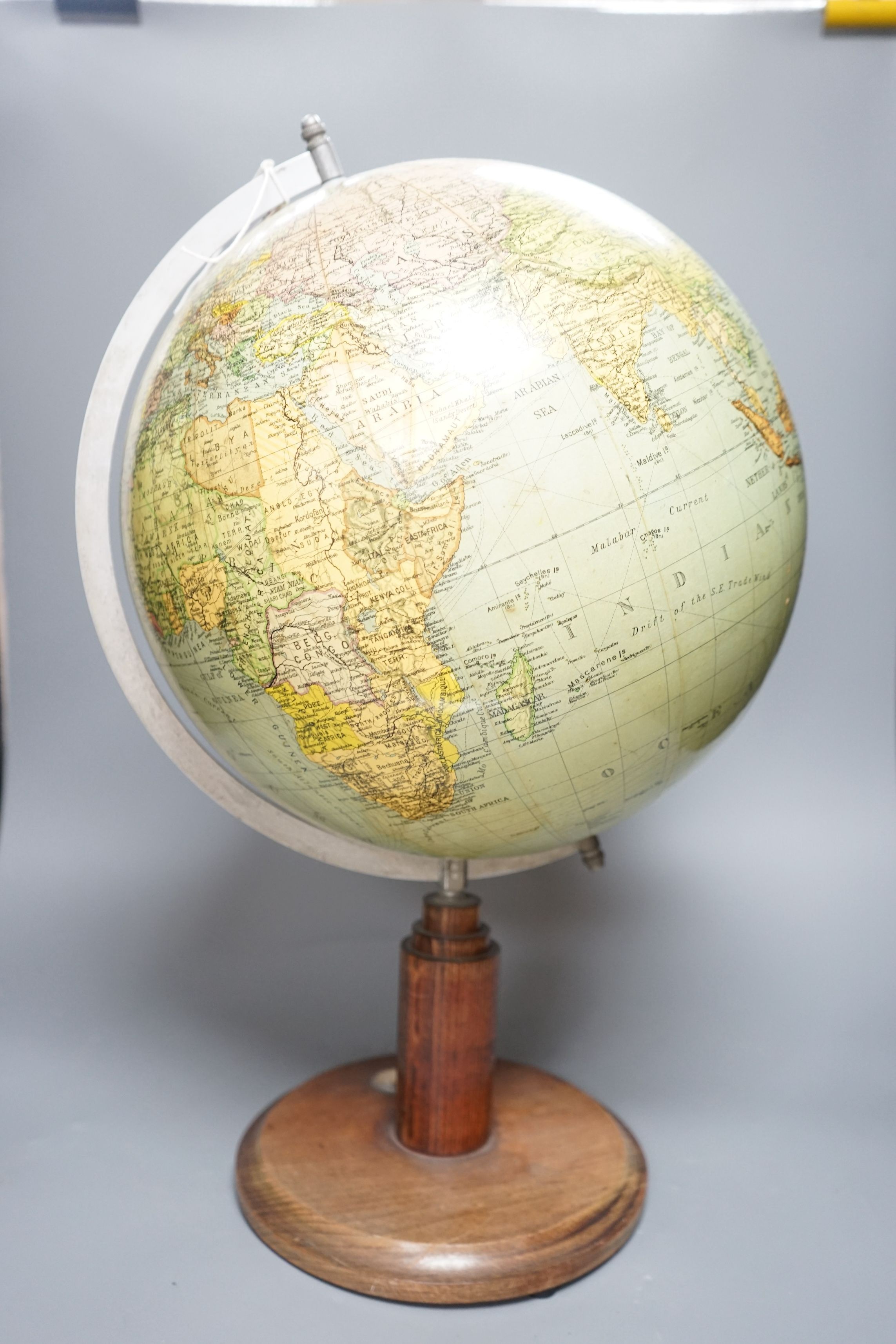 A mid 20th century globe on a revolving stand with an inset compass, 54cms high including stand